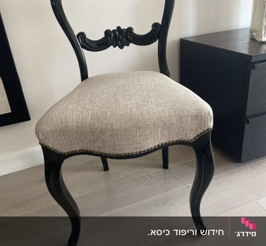 כיסא עם ריפוד בד בהיר ורגליים מעוצבות